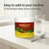 gutbloom with glass of water and spoon, promoted as a simple morning routine GutBloom (For Gut Health)
